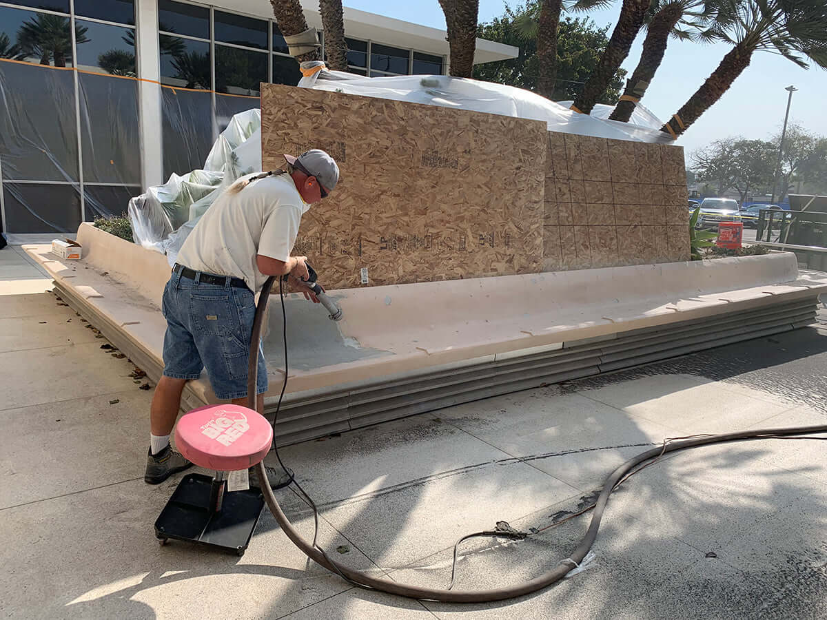 Worker using Like Nu Concrete Restoration Kit to repair an outdoor concrete structure