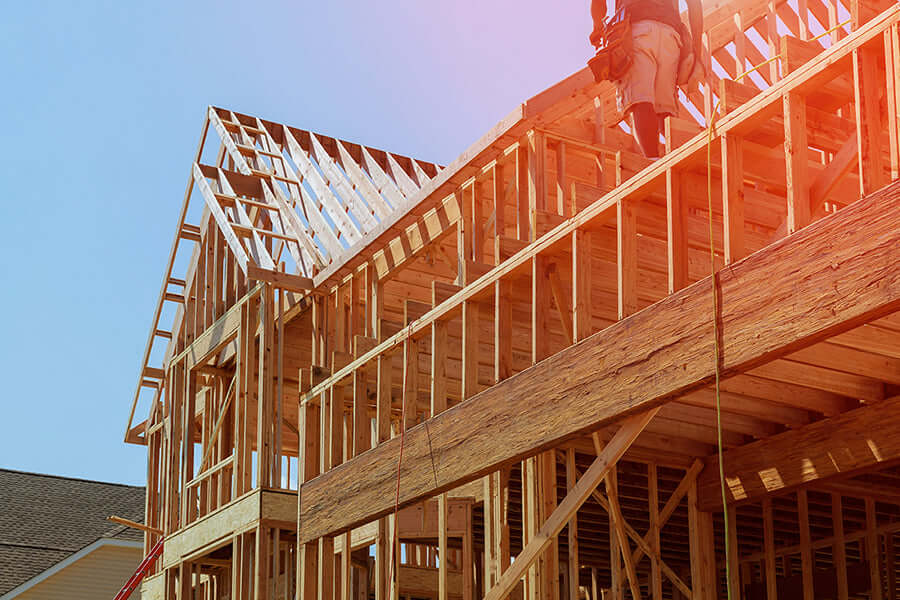 Construction workforce building a wooden commercial structure under blue skies - Like Nu Commercial Services.