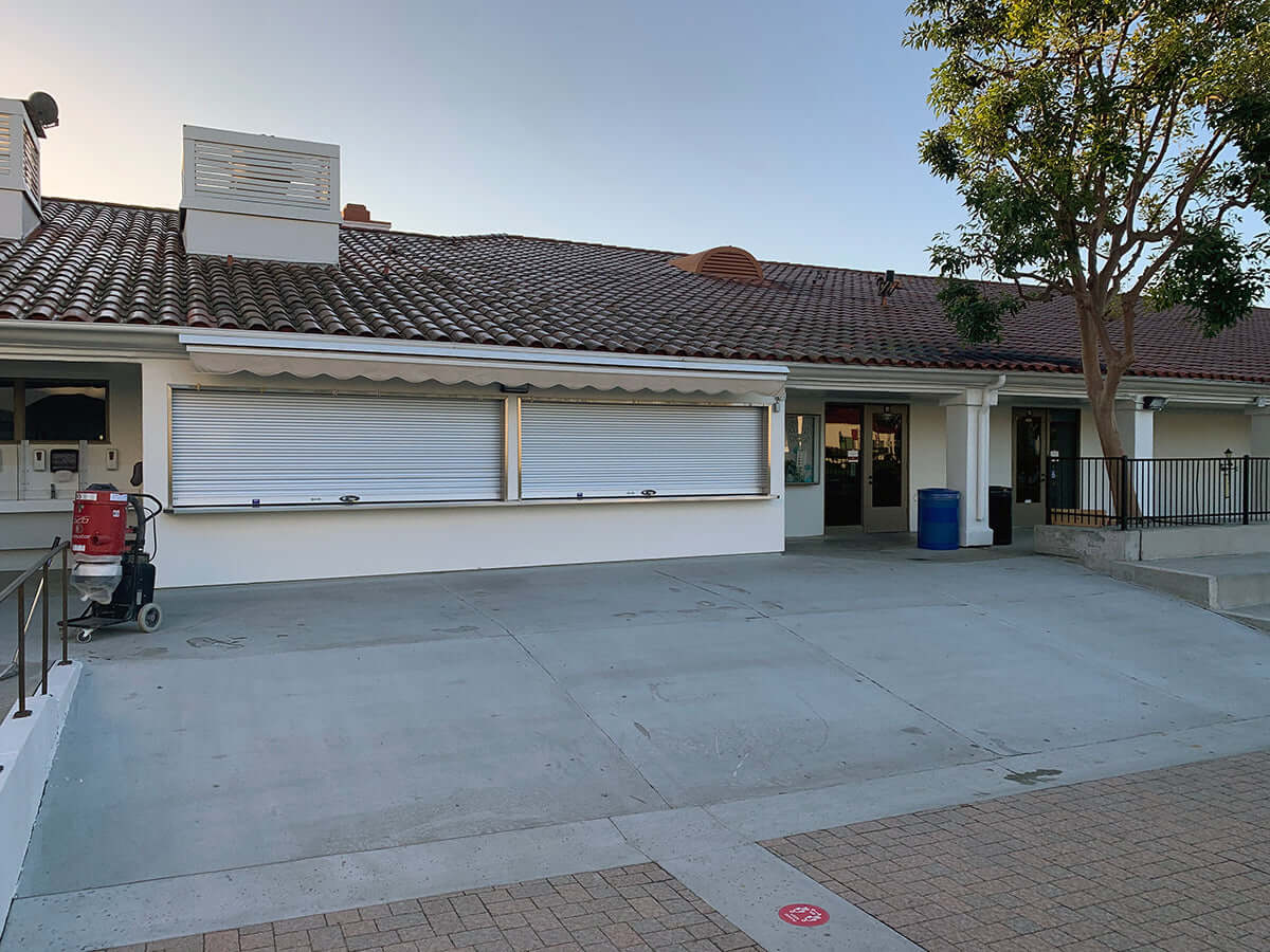 Like Nu Concrete Resurfacing front area of commercial building with smooth, renewed concrete surface and exterior view with trees.