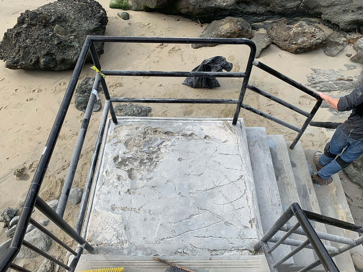 Damaged concrete stairs by the beach, ideal for Like Nu Concrete Restoration Kit usage.