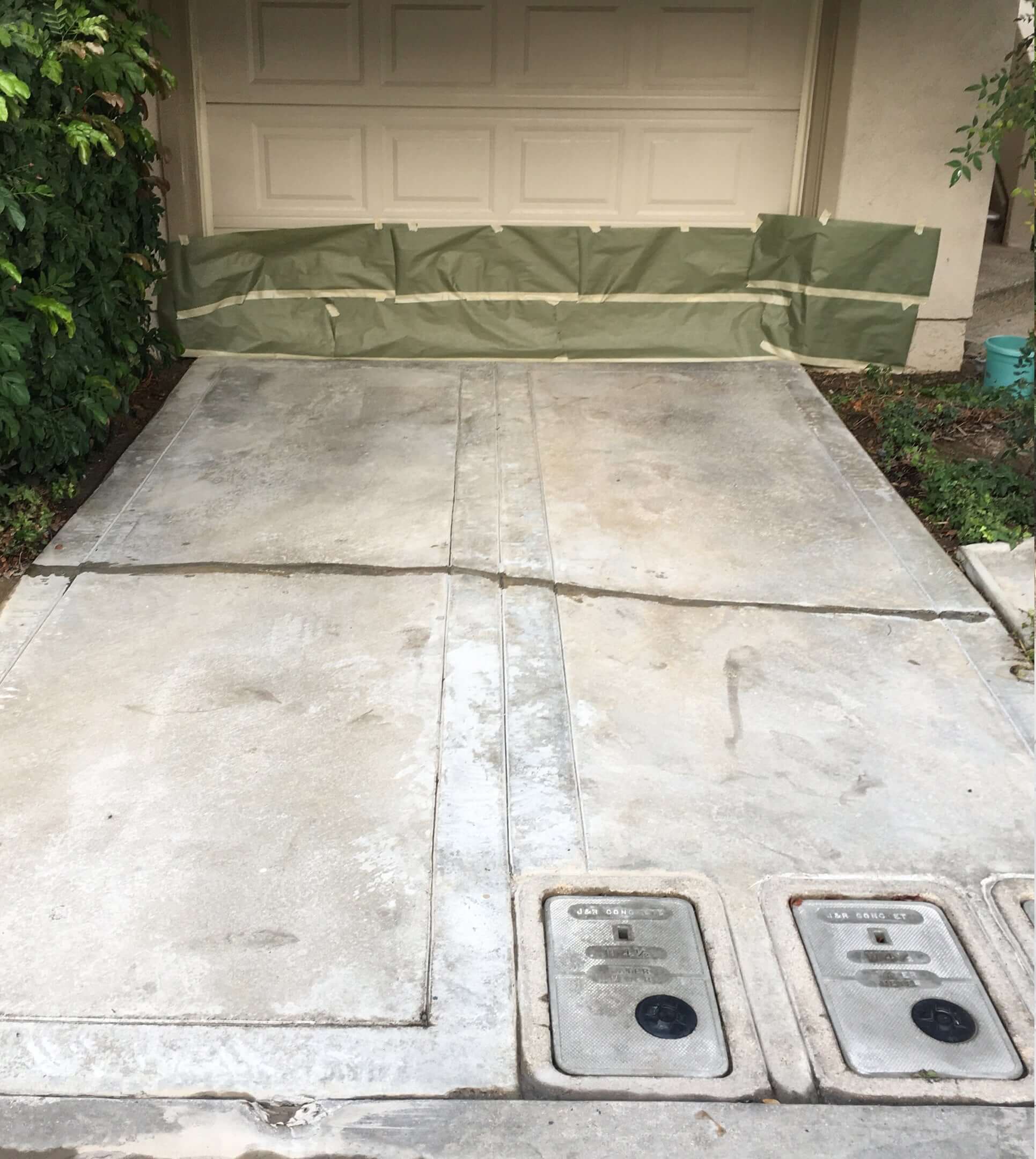 Concrete driveway prepared for Like Nu Concrete Restoration Kit application in front of a garage door.