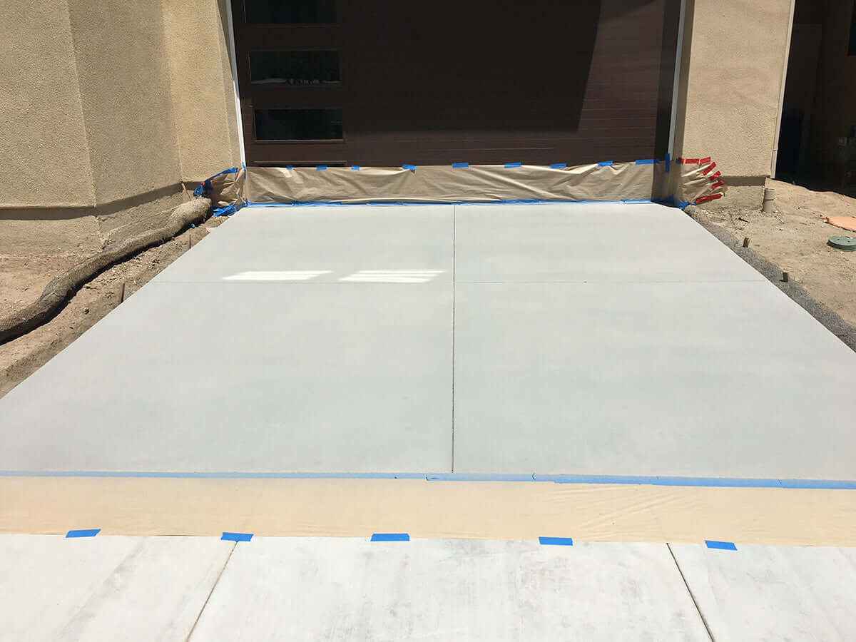 Freshly restored driveway with Like Nu Concrete Restoration Kit in front of a garage, highlighting smooth and even concrete finish.