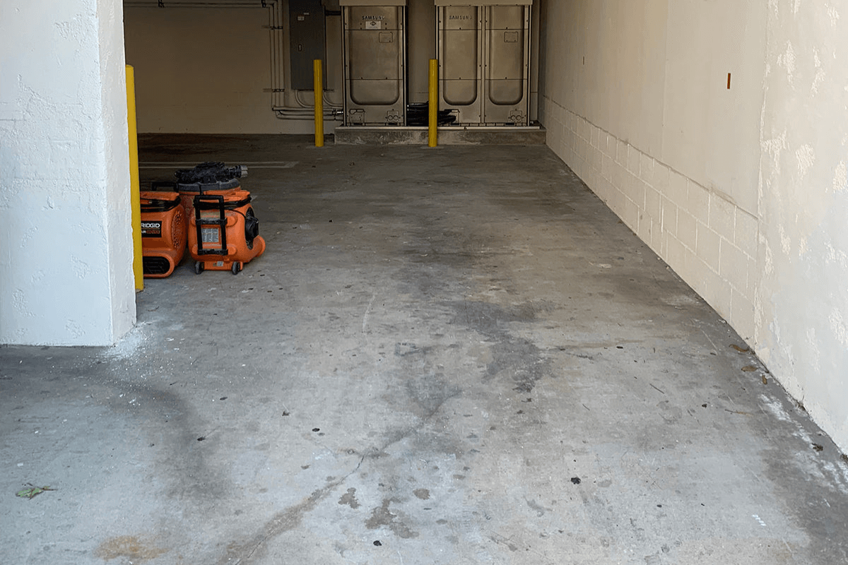 Worn-out concrete garage floor before Like Nu Concrete Resurfacing makeover showing visible stains and cracks.