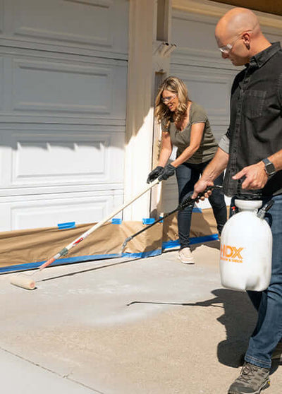 Couple applying Like-Nu Concrete mix to their driveway, showing effective concrete restoration techniques.