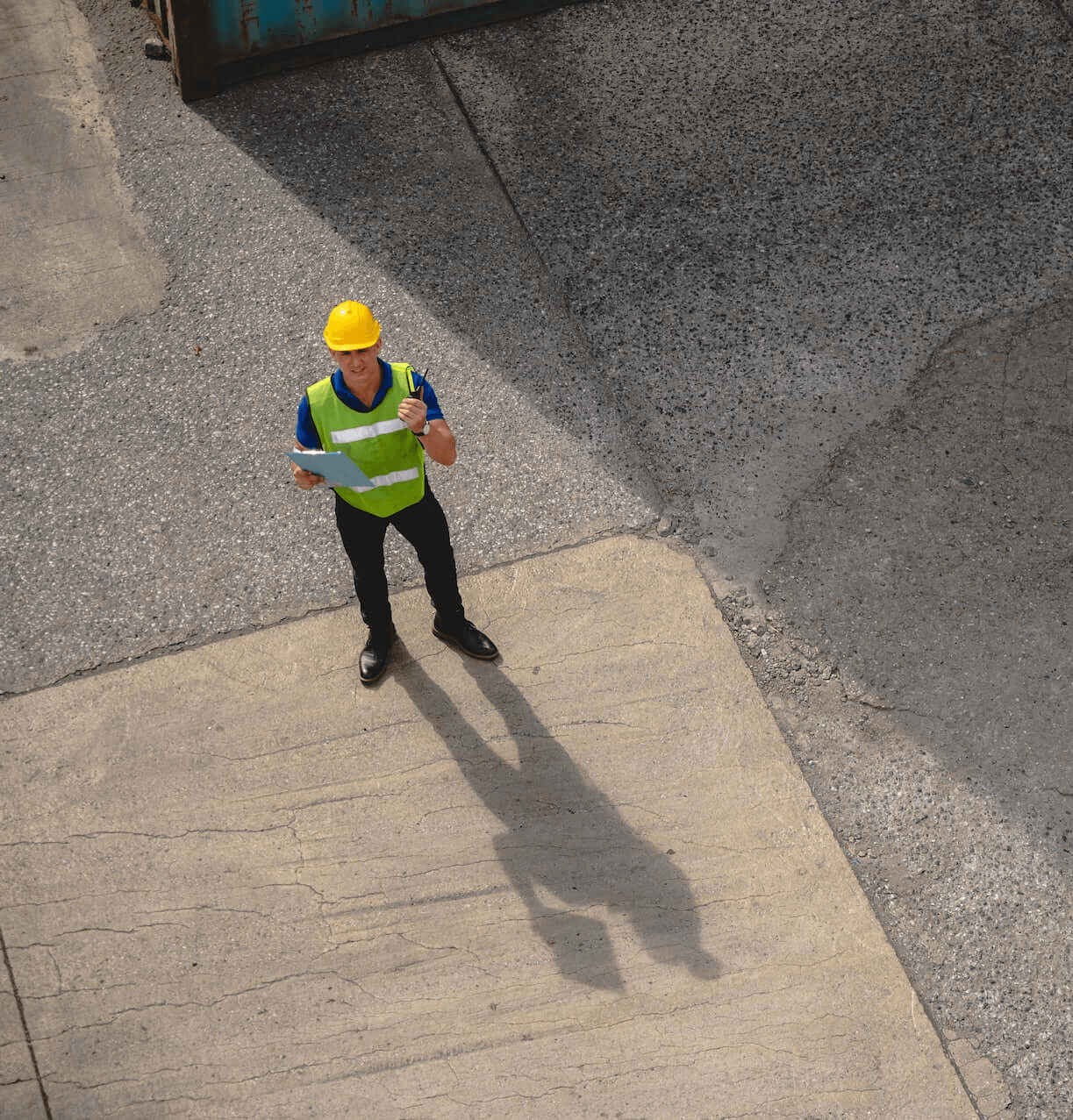 Construction worker inspecting site for concrete resurfacing project.